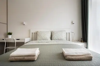 a white bedroom with a large bed with two pillows at Skansen Vilnius City Center in Vilnius