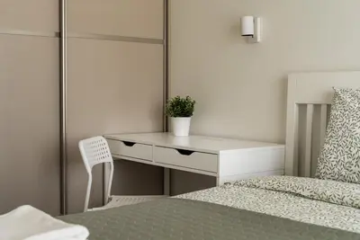 a bedroom with a white desk next to a bed at Skansen Vilnius City Center in Vilnius