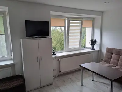 a living room with a tv on top of a cabinet at Prie Agluonos in Biržai