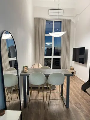 a dining room with a table and chairs and a television at Locusdo Apartment Nr 32 in Vilnius