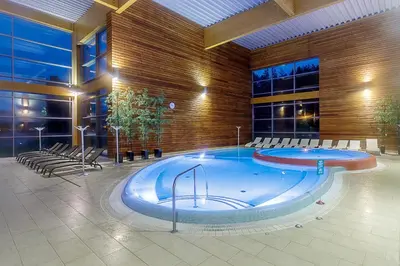 a large pool in a building with chairs around it at Medical SPA 