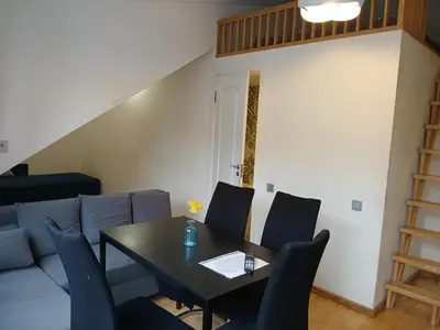 a dining room with a table and a couch at Spacy apartment on Laisves avenue in Kaunas