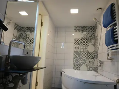 a bathroom with a sink and a tub and a mirror at Spacy apartment on Laisves avenue in Kaunas