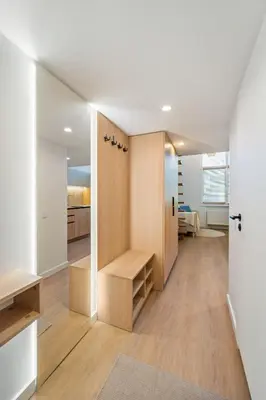 a room with a hallway with wooden cabinets and a kitchen at Lovely new loft in Vilnius centre self-check in in Vilnius