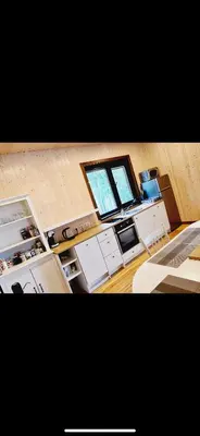 a kitchen with white cabinets and a window at Čičirio krantas in Vėdariai