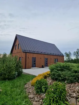a large wooden barn with a black roof at Modern design in quiet nature