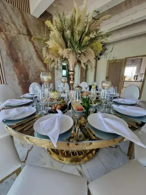 a dining room with a table with white chairs and a centerpiece at Modern design in quiet nature