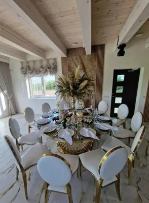 a dining room with a long table and white chairs at Baltasis beržas