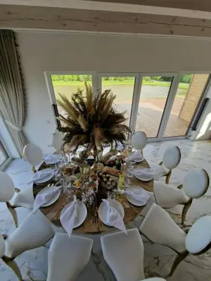 a dining room with a table and white chairs at Baltasis beržas
