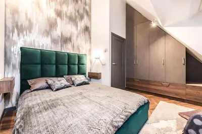 a bedroom with a green bed and a staircase at Modern I Penthouse Apt w - AC I Cohost in Vilnius