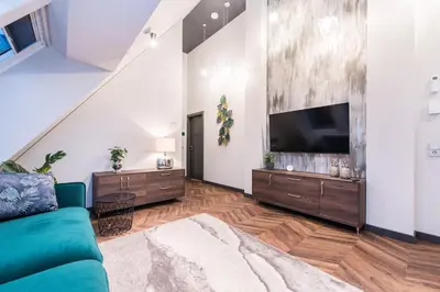 a living room with a blue couch and a flat screen tv at Modern I Penthouse Apt w - AC I Cohost in Vilnius