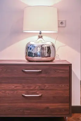 a lamp sitting on top of a wooden dresser at Modern I Penthouse Apt w - AC I Cohost in Vilnius