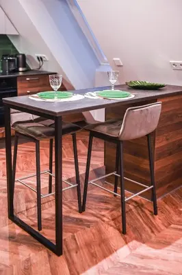 a black dining table with two chairs and glasses on it at Modern I Penthouse Apt w - AC I Cohost in Vilnius