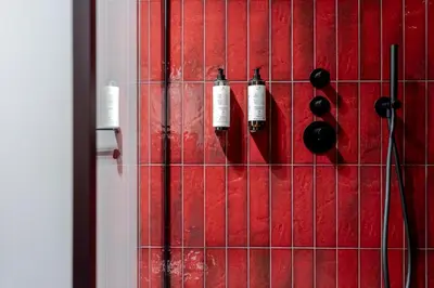 a red tiled wall with three wine bottles on it at 69 Fetish Apartments with Free Underground Parking in Kaunas