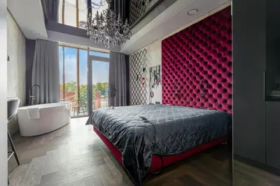 a bedroom with a bed and a red headboard at 69 Fetish Apartments with Free Underground Parking in Kaunas