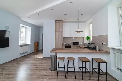 a kitchen with three bar stools and a counter at Old Town Peace Haven in Vilnius