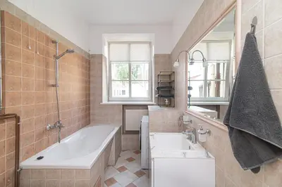 a bathroom with a tub and a sink and a mirror at Old Town Peace Haven in Vilnius