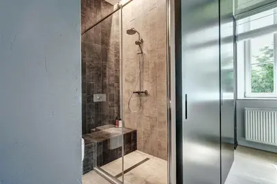 a bathroom with a shower with a glass door at City Heart One-Bedroom, 15 in Vilnius