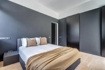a bedroom with a large bed with black walls at City Heart One-Bedroom, 15 in Vilnius