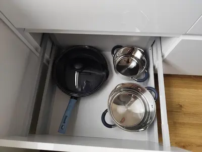 three pots and pans in a kitchen cabinet at Stay Rokiškis apartments in Rokiškis