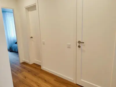 an empty room with a white door and wooden floors at Stay Rokiškis apartments in Rokiškis