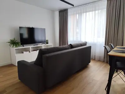 a living room with a couch and a flat screen tv at Stay Rokiškis apartments in Rokiškis