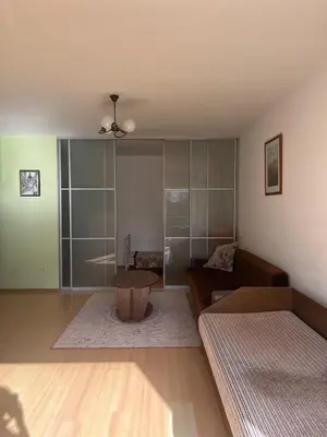 a living room with a couch and a table at Cozy apartment near Santariskes in Vilnius