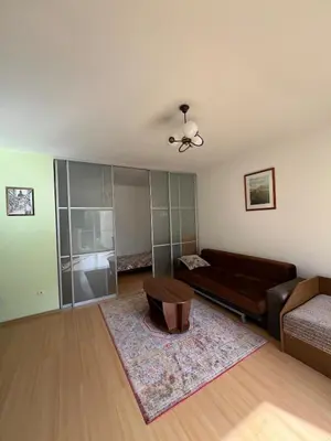 a living room with a couch and a table at Cozy apartment near Santariskes in Vilnius
