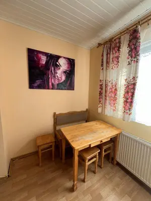 a dining room with a wooden table and a window at Cozy apartment near Santariskes in Vilnius
