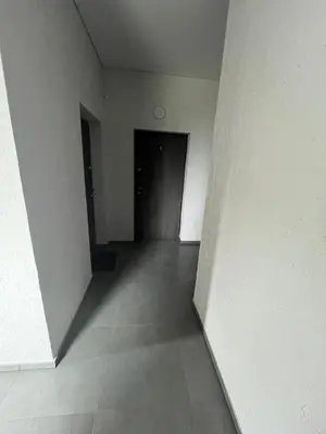 an empty hallway with a black door and white walls at 1 kambario apartamentai in Raseiniai