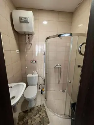 a bathroom with a shower and a toilet and a sink at 1 kambario apartamentai in Raseiniai