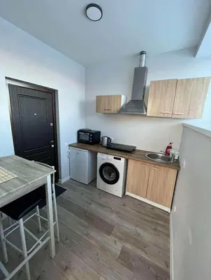 a small kitchen with a table and a stove at 1 kambario apartamentai in Raseiniai