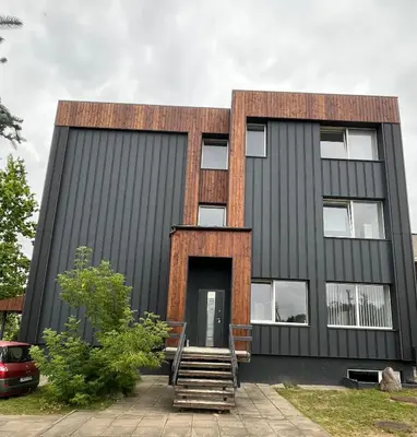 a black building with a stairway in front of it at 1 kambario apartamentai in Raseiniai