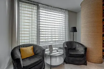 a living room with two chairs and a glass table at SPA apartments in city centre in Vilnius