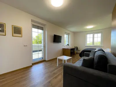 a living room with a couch and a table at Kulpe Guest Rooms