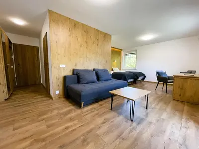 a living room with a blue couch and a table at Kulpe Guest Rooms