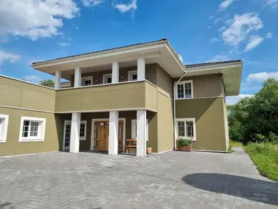 a large house with a driveway in front of it at Kulpe Guest Rooms