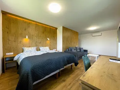 a bedroom with a bed and a couch and a table at Kulpe Guest Rooms