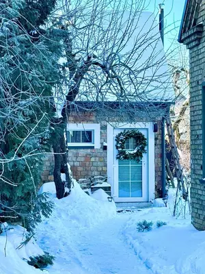 a house with a snow covered yard in front of it at Charming Cottage - Sauna - Central Location in Šiauliai