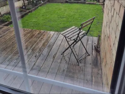 a chair sitting on a deck in a yard at Charming Cottage - Sauna - Central Location in Šiauliai