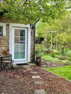 a house with a white door and a bench at Charming Cottage - Sauna - Central Location in Šiauliai
