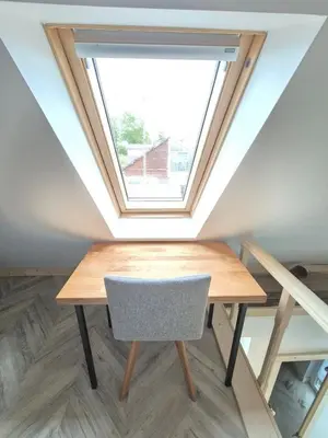 a table with a chair in a room with a window at Charming Cottage - Sauna - Central Location in Šiauliai