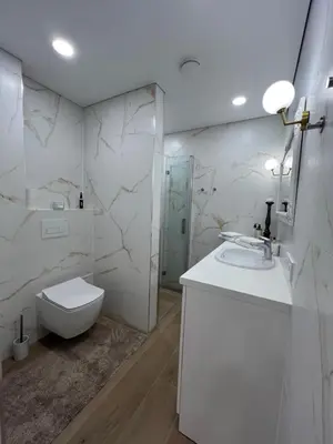 a white bathroom with a toilet and a sink at Skaidiškės Guesthouse in Skaidiškės