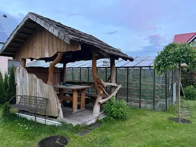 a wooden hut with a table in a yard at Skaidiškės Guesthouse in Skaidiškės