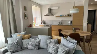 a living room with a couch and a table with pillows at Maironis apartment - Cozy apartment in Raseiniai in Raseiniai