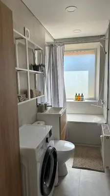 a bathroom with a washing machine and a toilet at Maironis apartment - Cozy apartment in Raseiniai in Raseiniai