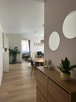 a living room with white walls and a table at Maironis apartment - Cozy apartment in Raseiniai in Raseiniai