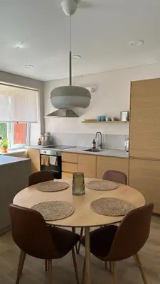 a kitchen with a table and chairs in a kitchen at Maironis apartment - Cozy apartment in Raseiniai in Raseiniai