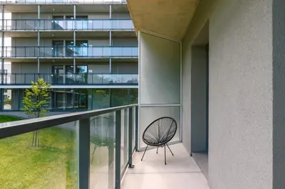 a chair on the balcony of a building at Liv in Vilnius OZAS in Vilnius