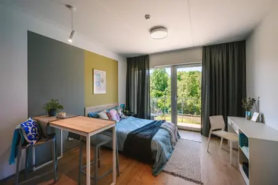 a bedroom with a bed and a desk and a table at Liv in Vilnius OZAS in Vilnius
